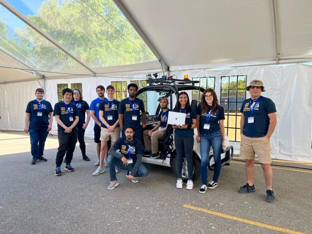 Members of the Kettering University Intelligent Ground Vehicle Competition Team pose in front of their cart.